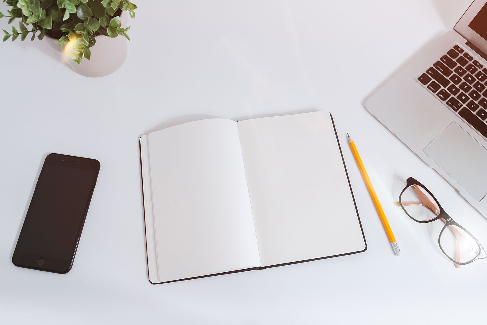 Notebook and laptop on a desk for writing a project brief